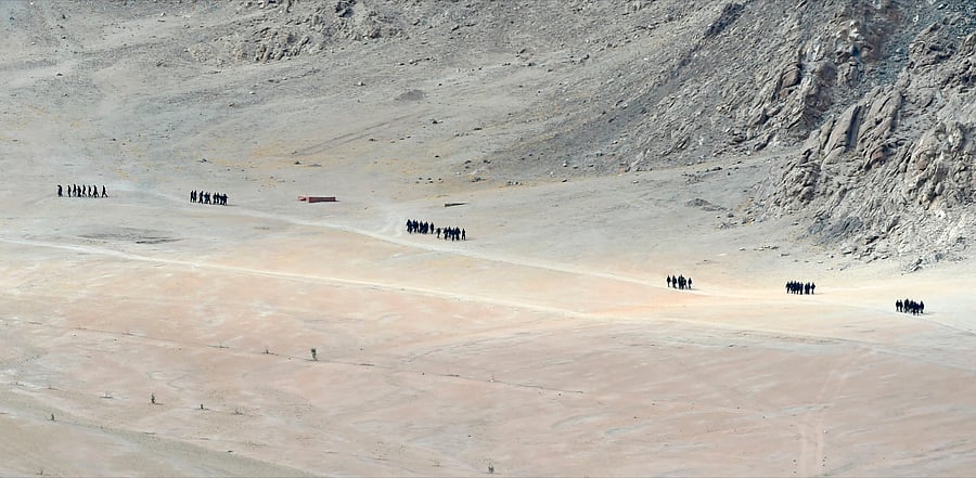 Indian soldiers walk at the foothills of a mountain range near Leh, the joint capital of the union territory of Ladakh. Credit: AFP Photo
