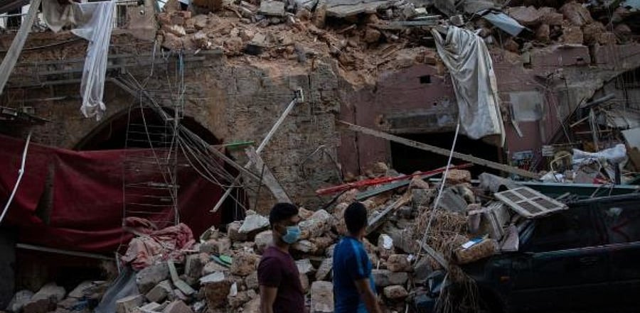 People walk past destroyed traditional Lebanese houses, following a massive explosion at the port area, in Beirut. Credit: Reuters