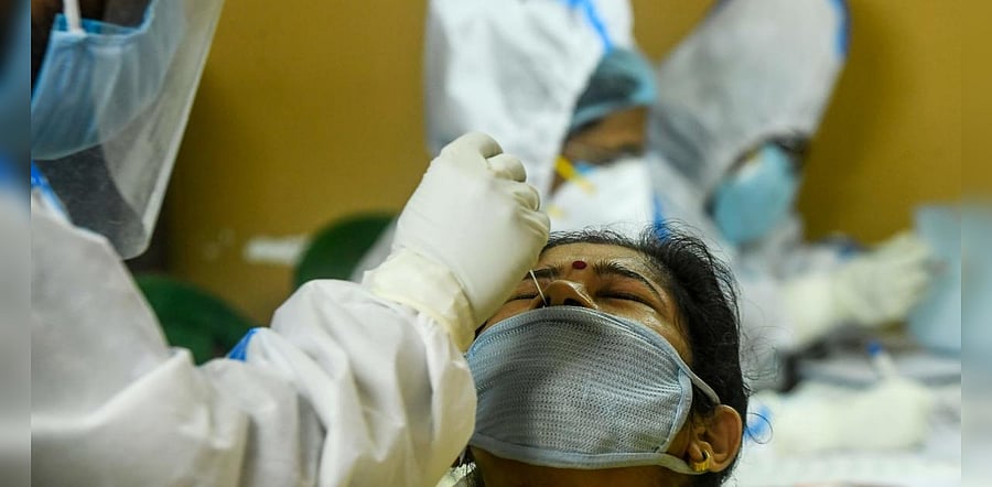 A health worker collects a swab sample from a resident of a housing society for COVID-19 coronavirus test during a door-to-door testing programme in Kolkata on August 23, 2020. Credit: AFP Photo