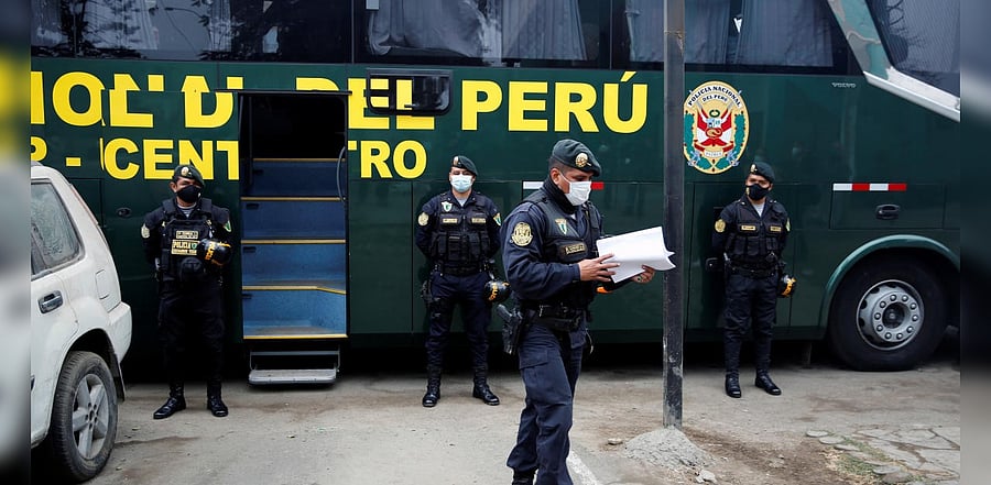 Police officers stand guard outside a bus with people who were detained when a nightclub was raided for hosting a party in violation of the coronavirus disease restrictions. Credits: Reuters