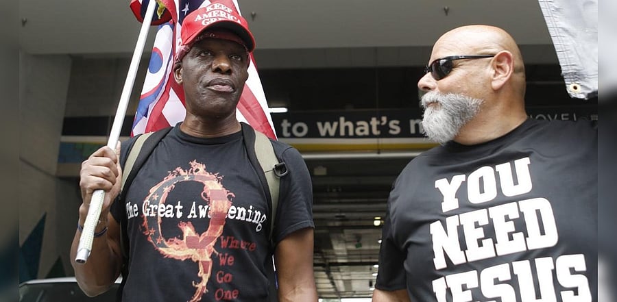 QAnon supporters talk about their political beliefs near the Republican National Convention. Credits: AFP
