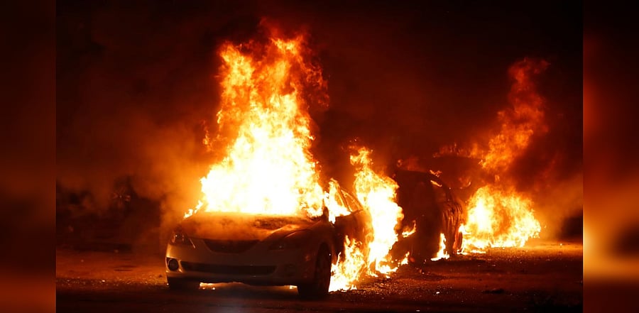 Flames roar from cars torched by protestors a few block from the County Court House during a demonstration against the shooting of Jacob Blake. Credit: AFP