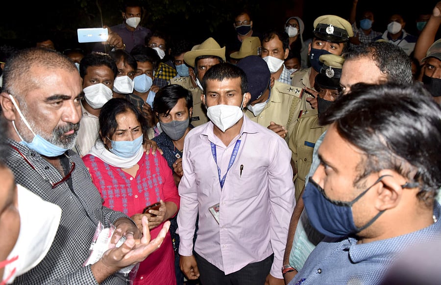 Angry doctors confront Dr Sudhakar, medical education minister, after Dr S R Nagendra killed himself. They allege IAS officer P K Mishra humiliated him over Covid testing targets.