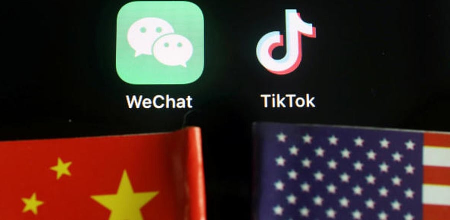 The messenger app WeChat and short-video app TikTok are seen near China and US flags. Credit: Reuters photo