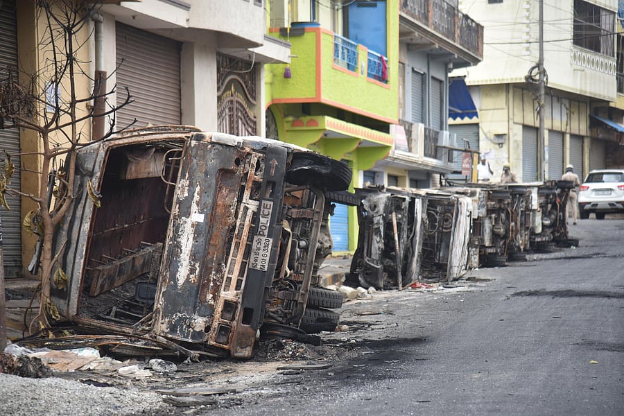 Burnt vehicles seen in front of DJ Halli Police Station in Bengaluru on Friday, 14 August 2020. Photo by S K Dinesh
