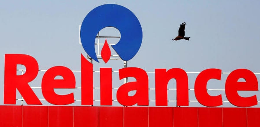 bird flies past a Reliance Industries logo. Credit: Reuters
