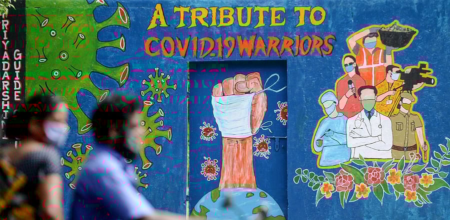 Motorists ride past a mural dedicated to frontline workers fighting against the spread of the Covid-19, in Chennai. Credit: AFP Photo