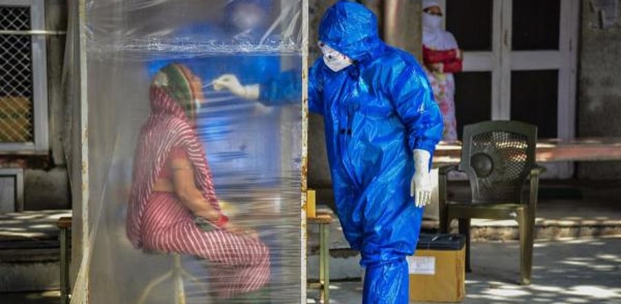 A medic collects samples from a woman for Covid-19 test, as coronavirus cases surge across the country. Credit: PTI Photo