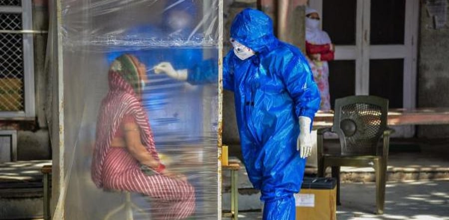 A medic collects samples from a woman for Covid-19 test. Credit: PTI