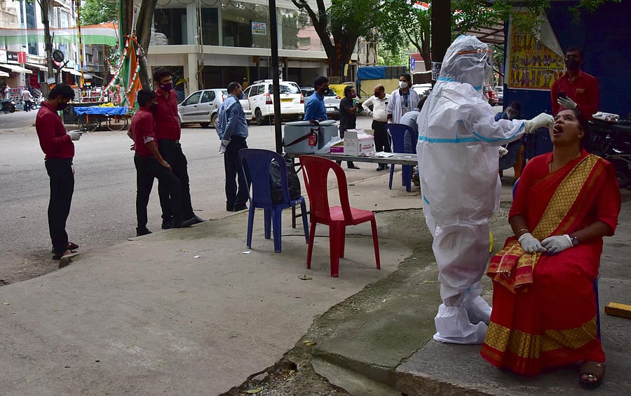 A healthcare worker takes the swab samples of a woman in Jayanagar, Bengaluru. DH PHOTO/IRSHAD MAHAMMAD