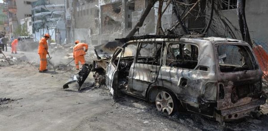 Afghan municipality workers work to clear up the site of an attack. Credit: AFP