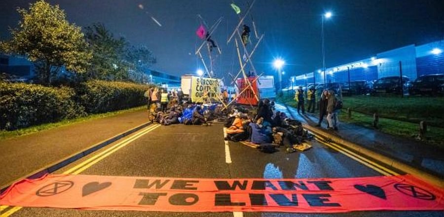 Extinction Rebellion activists blocking the entrance to the News Corporation newpaper printers at Broxbourne, north of London. Credit: AFP Photo
