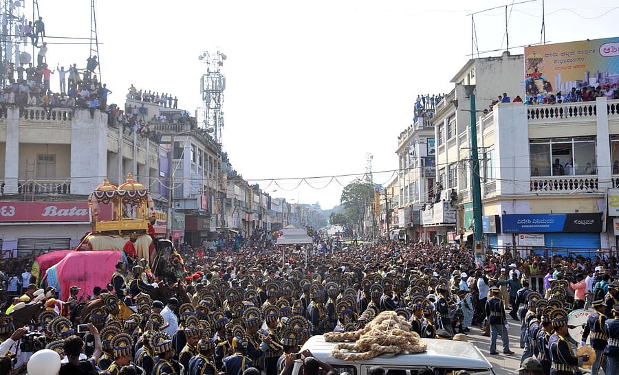 People watch Jamboo Savari as part of Mysuru Dasara at KR Circle, with D Devaraja Urs Road in the background.