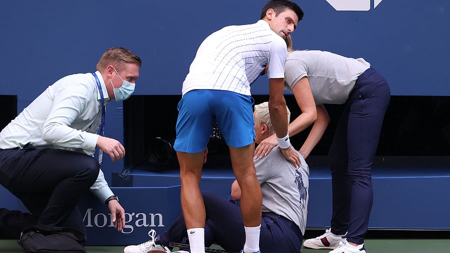 Novak Djokovic of Serbia tends to a line judge who was hit with the ball during his Men's Singles fourth round match against Pablo Carreno. Credits: AFP Photo