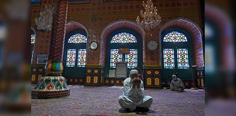 Muslim devotees wearing facemasks pray inside the Sheikh Abdul Qadir Geelani shrine in downtown Srinagar/ Representation. Credit: AFP