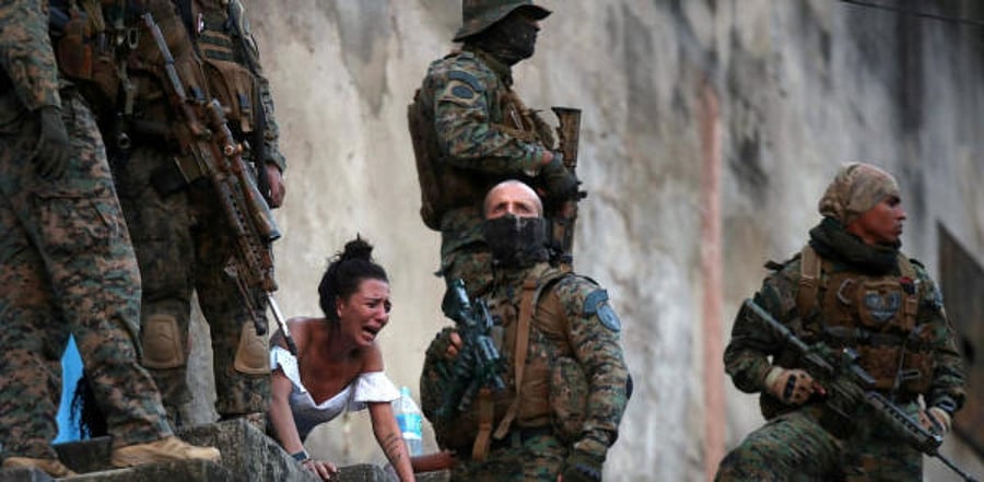 A woman reacts next to the body of a person who was shot near Sao Carlos slums complex during a police operation after heavy confrontations between drug gangs in Rio de Janeiro. Credit: Reuters