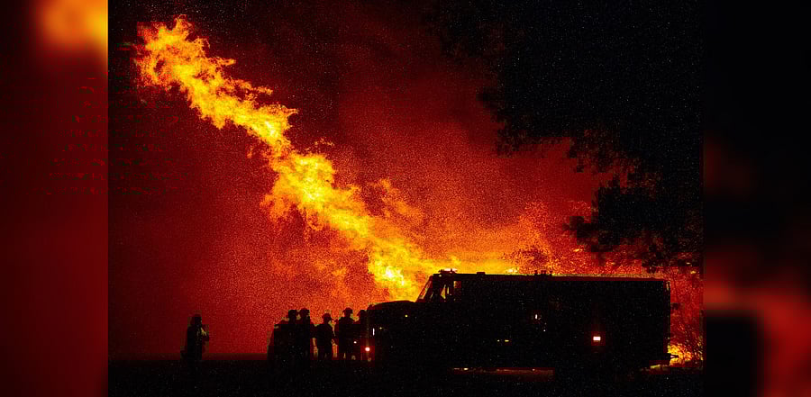 Butte county firefighters watch as flames tower over their truck at the Bear fire in Oroville, California on September 9, 2020. - Dangerous dry winds whipped up California's record-breaking wildfires and ignited new blazes, as hundreds were evacuated by helicopter and tens of thousands were plunged into darkness by power outages across the western United States. Credit: AFP Photo