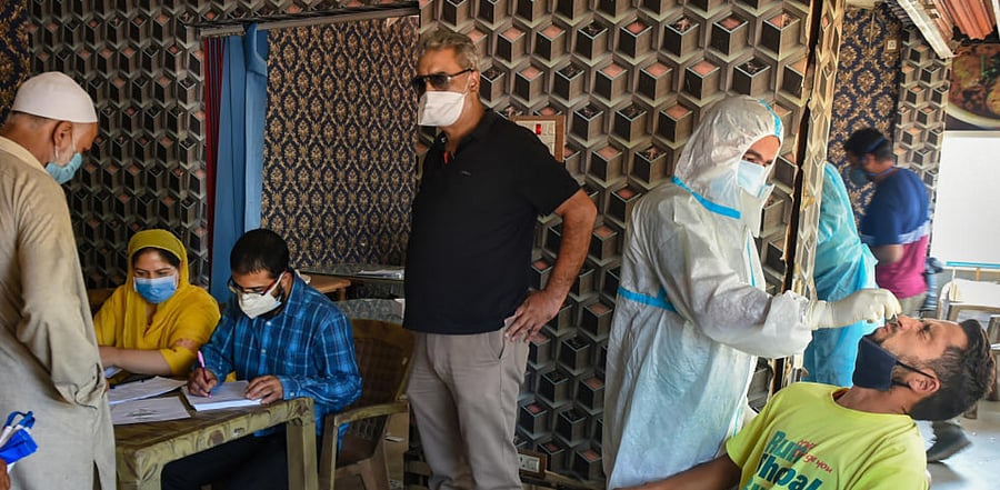 A health worker wearing a PPE kit collects a nasal sample from a driver via Rapid Antigen kit for Covid-19 test, outside a bus terminal in Srinagar, Thursday, Sept. 10, 2020. Credit: PTI Photo