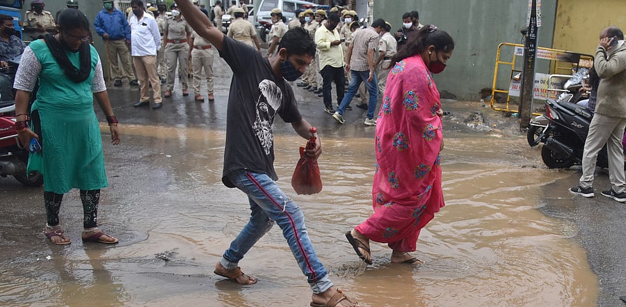 People walking around puddles in Bengaluru. Credit: DH Photo