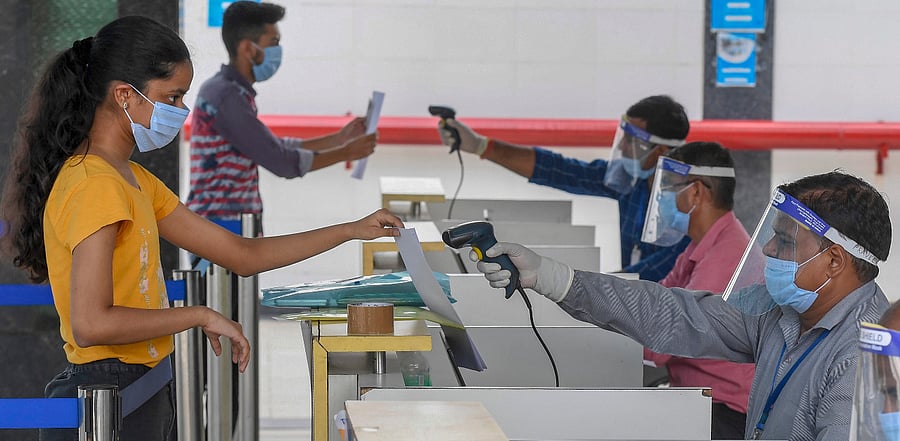 Students undergo thermal scanning as they arrive at an examination centre to appear in Joint Entrance Examination (JEE ) Main-2020 amid Covid-19 pandemic, in Noida. Credit: PTI Photo