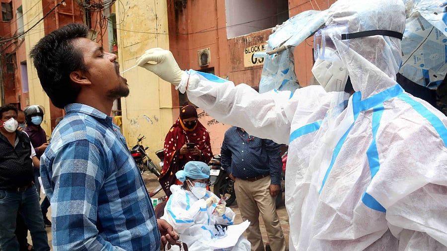 A medic collects swab samples from a man as part of a statewide door-to-door 'Kill Corona' campaign to curb the spread of coronavirus. Credits: PTI Photo