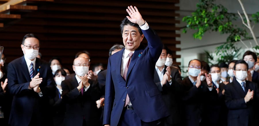 Japan's outgoing Prime Minister Shinzo Abe wave to staff members as they applaud to bid him goodbye at his official residence in Tokyo, Japan. Credit: Reuters Photo 