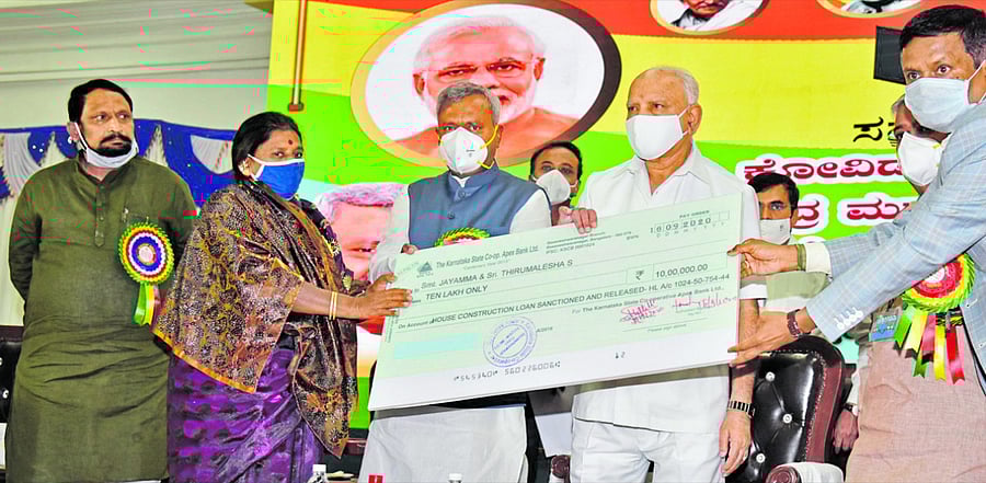 B S Yediyurappa, Chief Minister distributing cheque to beneficiaries at Central Government and State Government financial assistance. Credit: DH Photo