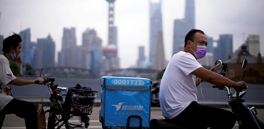 Delivery workers wearing face masks ride scooters in China amid the coronavirus pandemic. Credit: Reuters