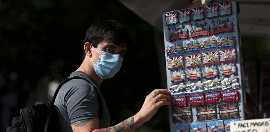 A man wears a protective face mask as he shops, amid the spread of the coronavirus disease, on the New Street in Birmingham, Britain. Credit: Reuters