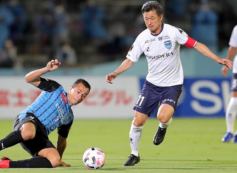 Yokohama FC forward Kazuyoshi Miura (R) is tackled by Kawasaki Frontale forward Leandro Damiao during the J-League football match between Kawasaki Frontale and Yokohama FC at Todoroki Athletics stadium in Kawasaki. Credit: AFP