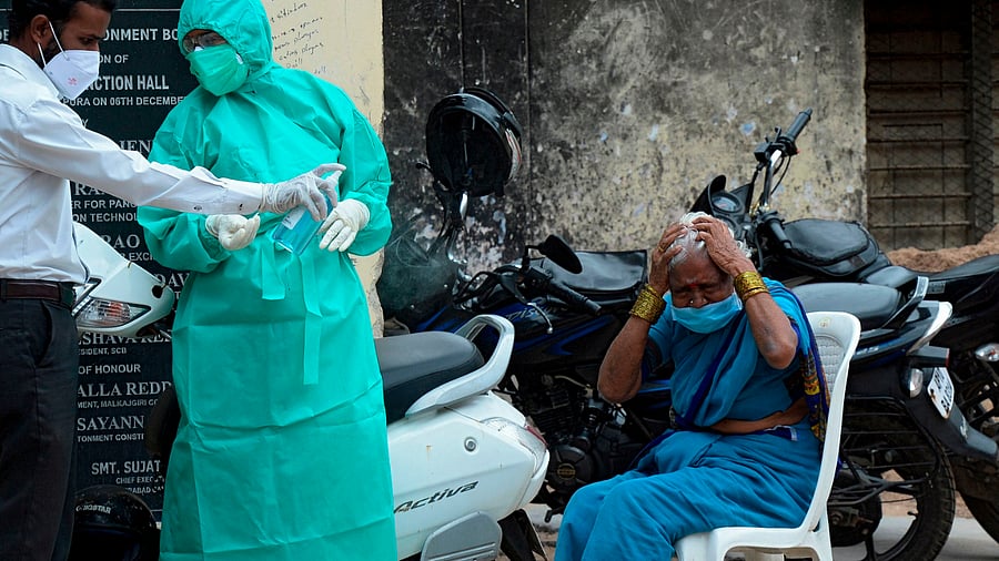 A woman reacts after giving her swab sample to a health worker to test for the Covid-19. Credits: AFP Photo