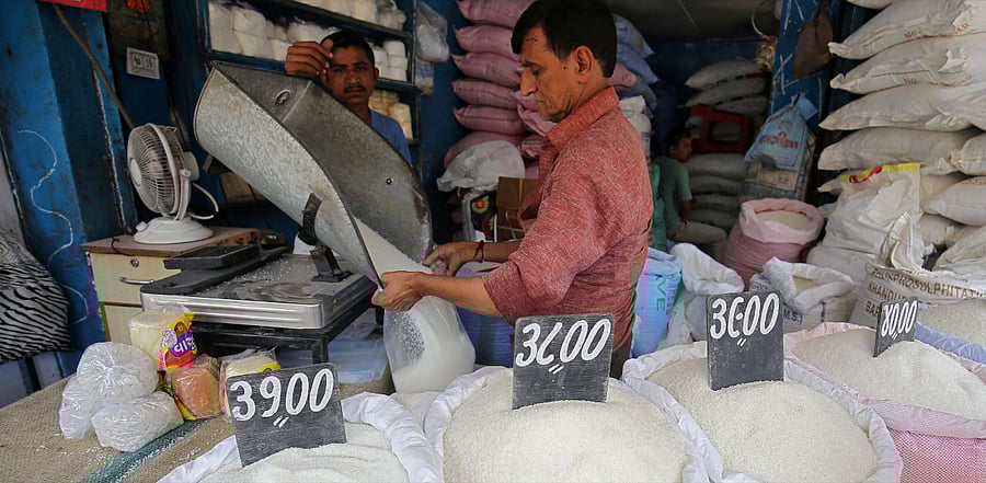 A man packs sugar for sale inside a shop at a marketplace in Ahmedabad. Credit: Reuters Photo