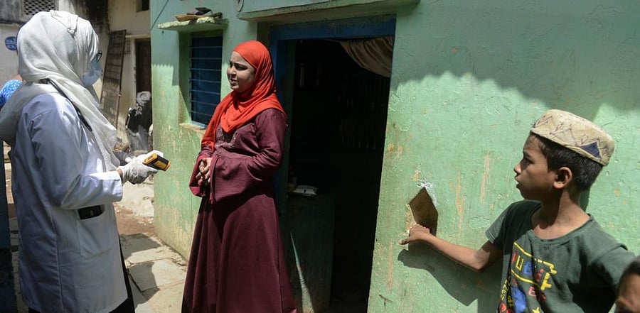 Neha Begum (L), a medical officer speaks to a woman during the health check-up of residents to test for the coronavirus at a slum area in Hyderabad. Credit: AFP