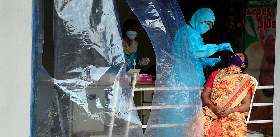 A health worker collects a swab sample from a woman for a Covid-19. Credit: AFP Photo