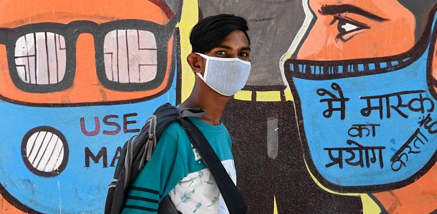 A man walks past a mural representing frontline warriors of the Covid-19, painted on the wall of a dumping ground in New Delhi on September 29, 2020. Credit: AFP Photo