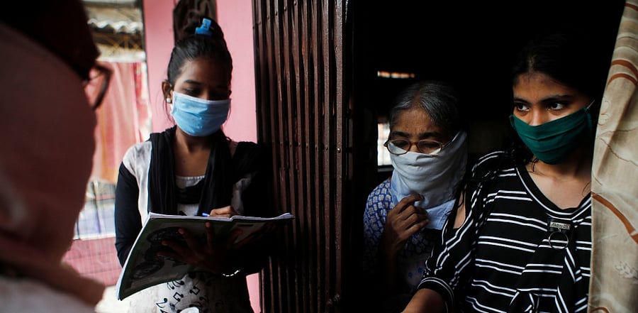 Community health volunteers check the pulse of a resident during a check-up campaign for the coronavirus. Credit: Reuters Photo
