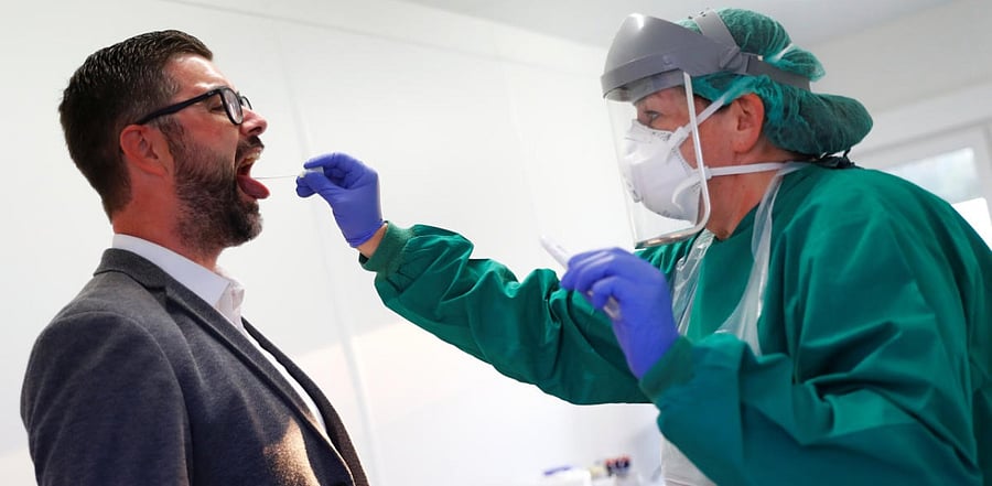 An employee of Bioscientia Healthcare takes a swab from a man at a test center as the spread of the coronavirus disease. Credit: Rueters