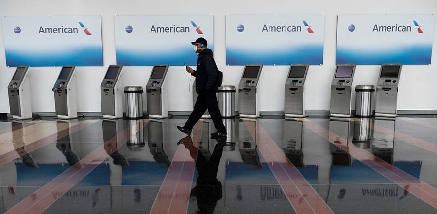 A passenger walks past empty American Airlines check-in terminals. Credit: AFP