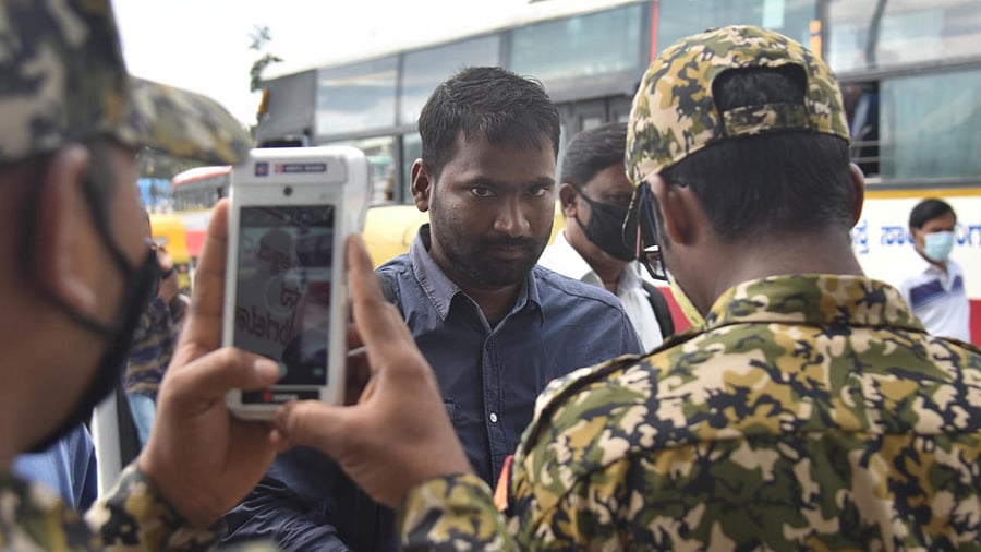 A man being fined for not wearing a mask at the KSRTC bus station in Bengaluru on Thursday. Credit: DH.