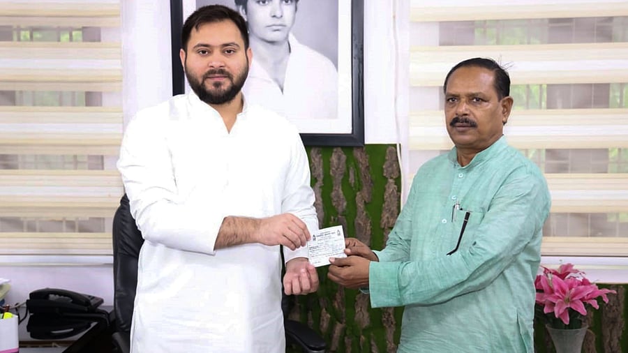 RJD leader Tejaswi Yadav presents party membership slip to Bahujan Samaj Party's Bihar President Bharat Bind as he joins the RJD. Credits: PTI Photo