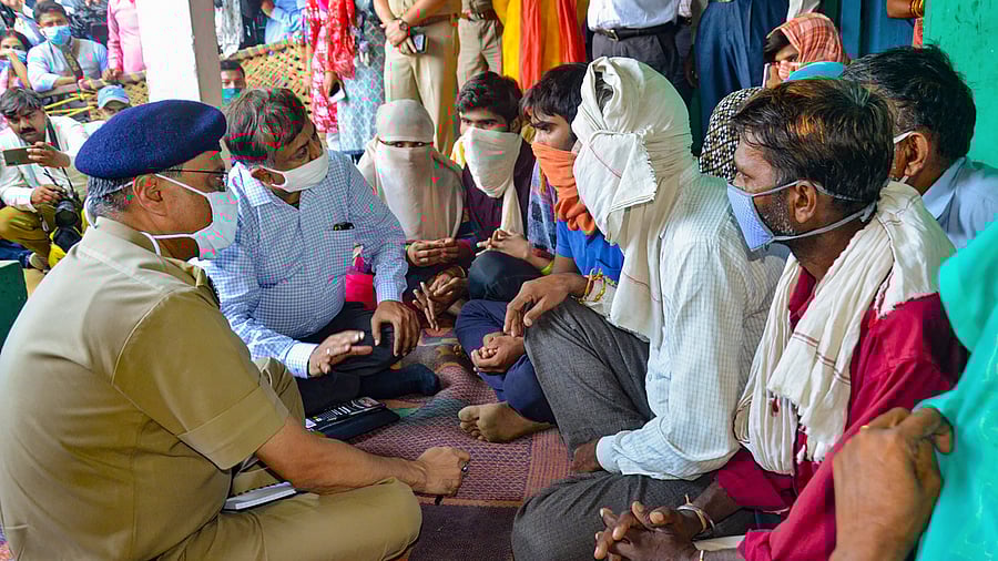 Additional Chief Secretary of Uttar Pradesh Awanish Kumar Awasthi meets the family members of a 19-year-old Dalit woman who died after being allegedly rape. Credits: PTI Photo