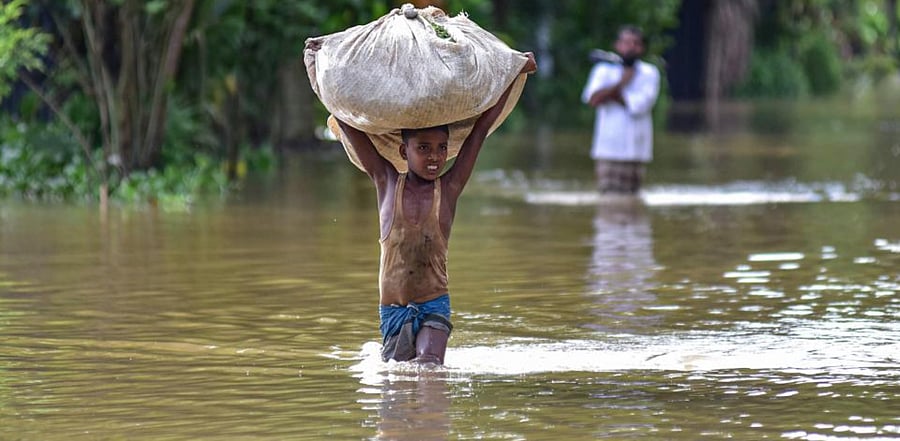 A boy wades through a flooded area, following heavy rainfall, in Nagaon district, Sept. 25, 2020. Credit: PTI Photo