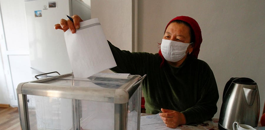 A woman casts a ballot at home during a parliamentary election in the village of Arashan, Kyrgyzstan. Credit: Reuters Photo