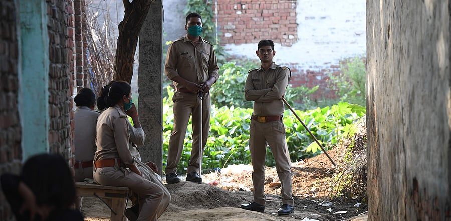 Police personnel stand guard outside the family house of a 19-year-old woman, who was allegedly gang-raped by four men, at Bool Garhi village in Hathras. Credit: AFP