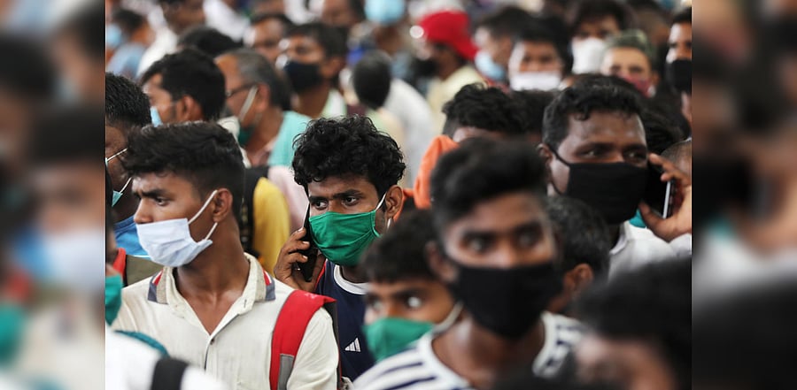 Migrants who returned from their hometown of Uttar Pradesh wait in line to be tested for the coronavirus disease during a rapid antigen testing campaign at a railway station, on the outskirts of Mumbai, India, October, 3, 2020. Credit: Reuters Photo