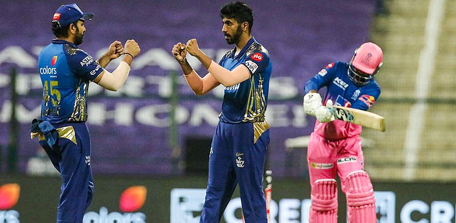 Mumbai Indians skipper Rohit Sharma and Jasprit Bumrah celebrate the wicket of Rajasthan Royals player Rahul Tewatia during IPL 2020 cricket match, at Sheikh Zayed Stadium in Abu Dhabi, United Arab Emirates. Credit: PTi Photo