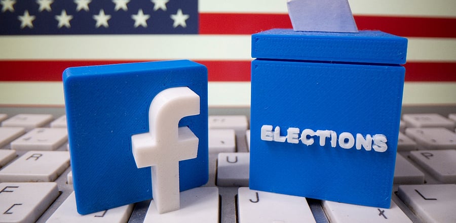 A 3D-printed elections box and Facebook logo are placed on a keyboard in front of US flag. Credit: Reuters Photo