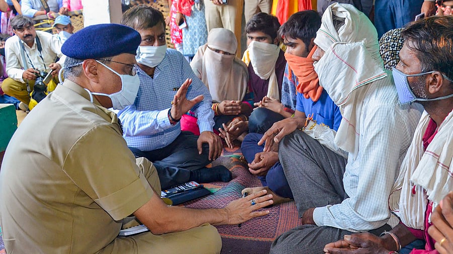 Additional Chief Secretary of Uttar Pradesh Awanish Kumar Awasthi meets the family members of a 19-year-old Dalit woman who died after being allegedly raped. Credits: PTI Photo