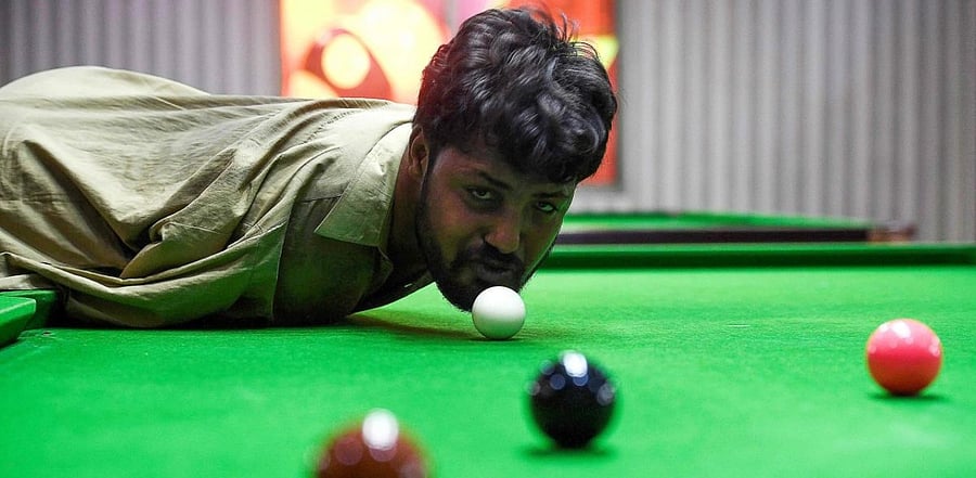 Ikram, who was born without arms, steps up to a snooker table, sizes up his options and with a firm flick of his chin strikes the cue ball and slots a red into a corner pocket. Credit: AFP
