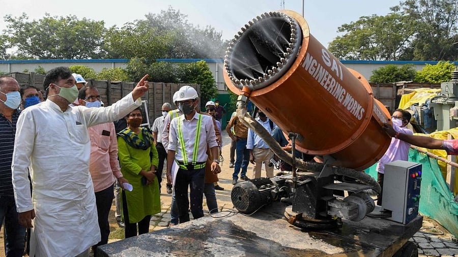 Delhi Government Environment Minister Gopal Rai (2L) gestures during a demonstration of an anti-smog gun used to control dust at the Integrated Exhibition-Cum-Convention Center (IECC) construction site in New Delhi. Credit: AFP.
